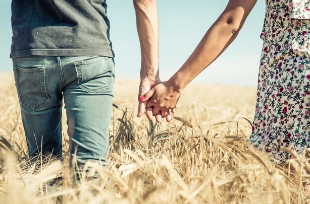 Two People Holding Hands in Straw Field - FarmersOnly