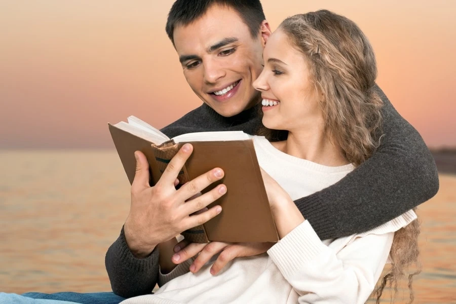 Couple smiling and reading the Bible together